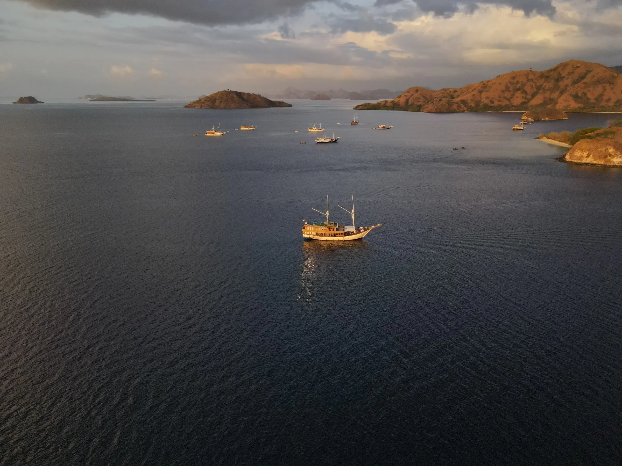 A phinisi boat at sunset in Komodo waters